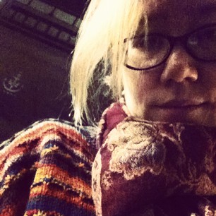 Sad hipster at the bus stop on a cold rainy night.
