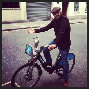 A beardy hipster in a handknit cardy riding a share bike through London. *swoon*