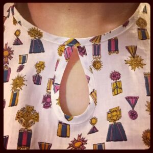 Close-up of fabric and neckline. It's got little medals all over it!