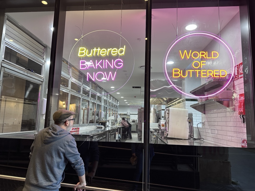 A man peers through a window into an empty bakery kitchen
