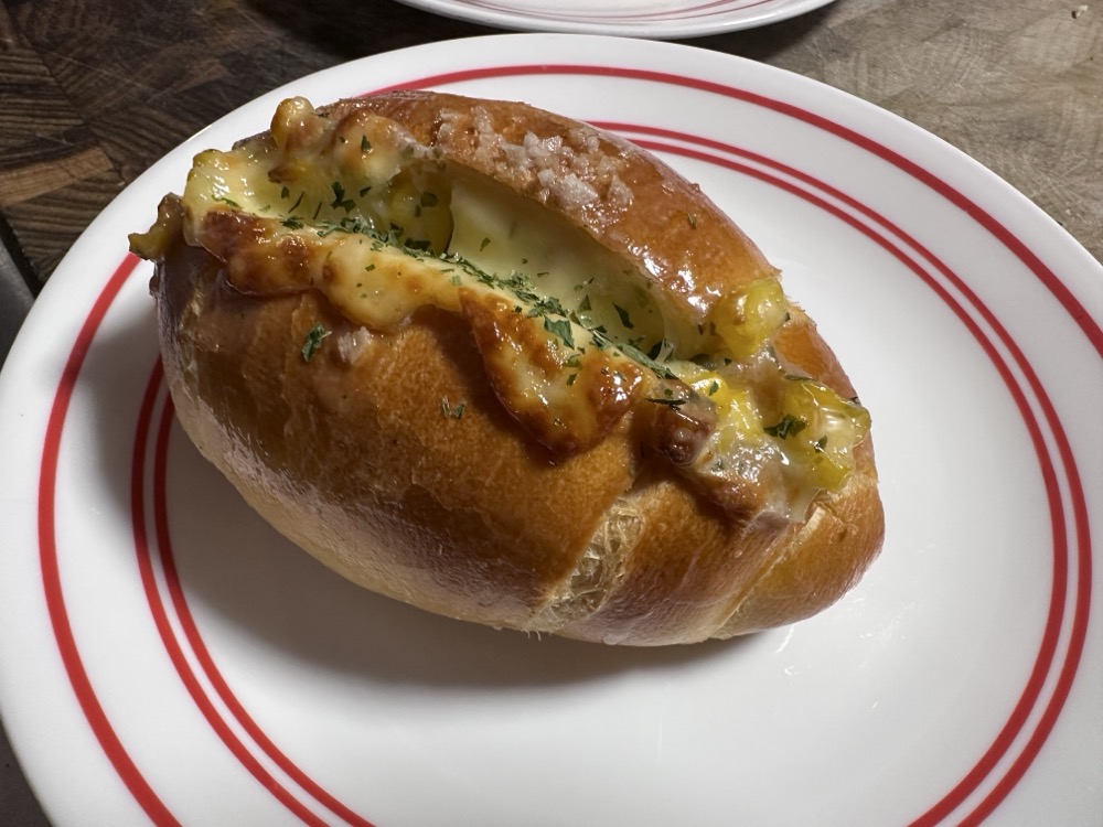 A corn cheese salt bread, which is a football shaped bread roll split down the middle and filled with melted cheese and sweetcorn