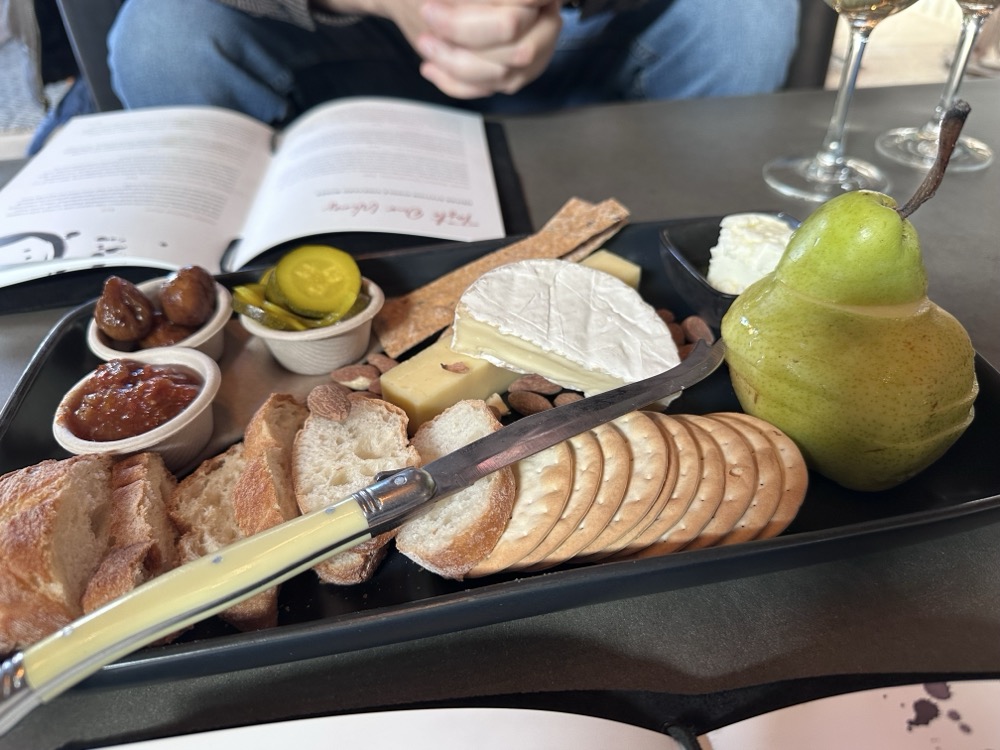 A cheese plate with crackers and a pear