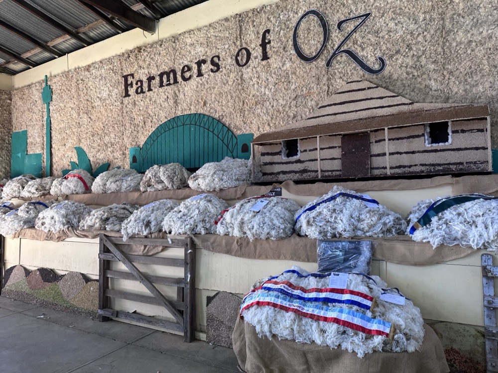 "Farmers of Oz" written on a wall above mounds of sheep wool