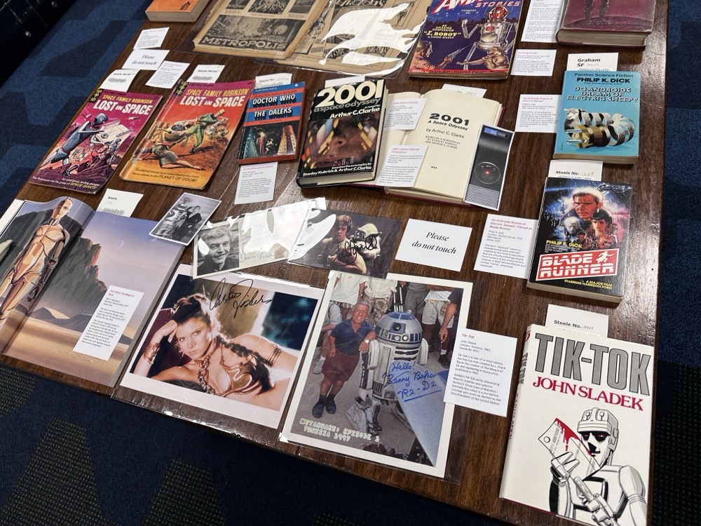 A table covered in pop-culture ephemera, including autographed photos from the cast of Star Wars