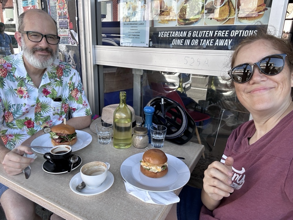 Two middle-aged hipsters eating lunch al fresco at a cafe on King Street, Newtown